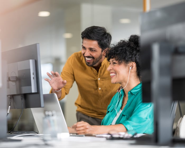 Two colleagues looking at a laptop together
